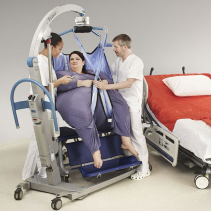 A plus size patient on a Tenor Bariatric Patient Lift while two nurses help her