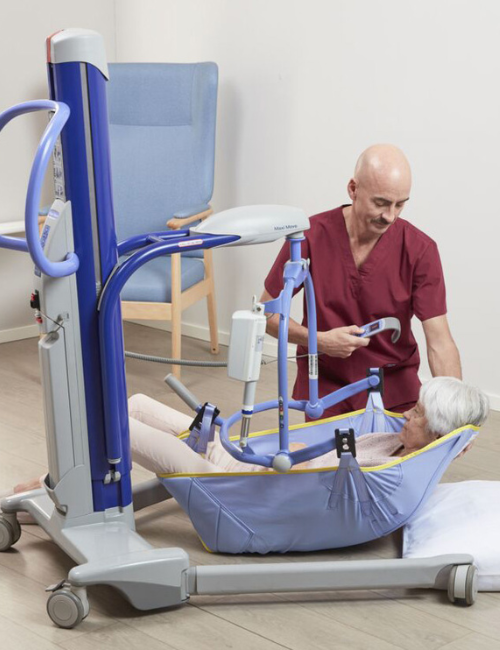 A nurse helping a disabled woman on a Arjo product